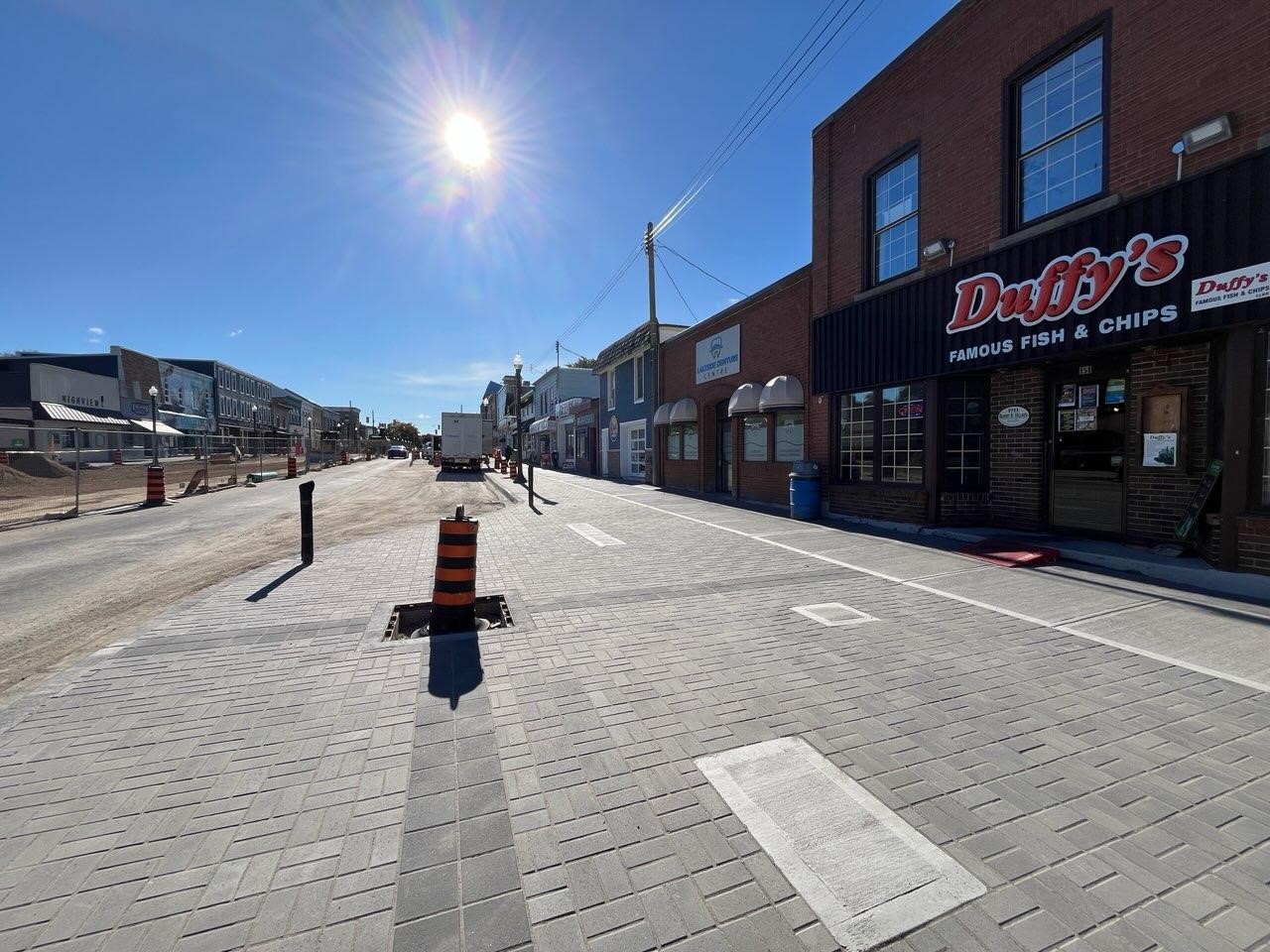 Photo of road construction with newly finished sidewalk and brick